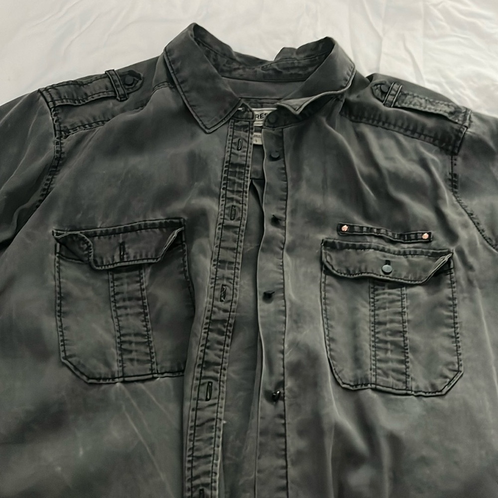 Grey button down shirt.